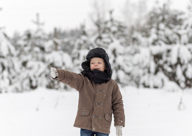 portret małego chłopca w zimowym lesie