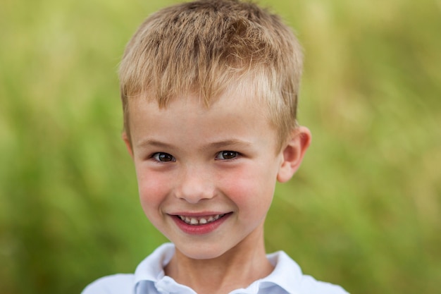 Portret małego uśmiechniętego chłopca ze złotym blond włosy słomy ja