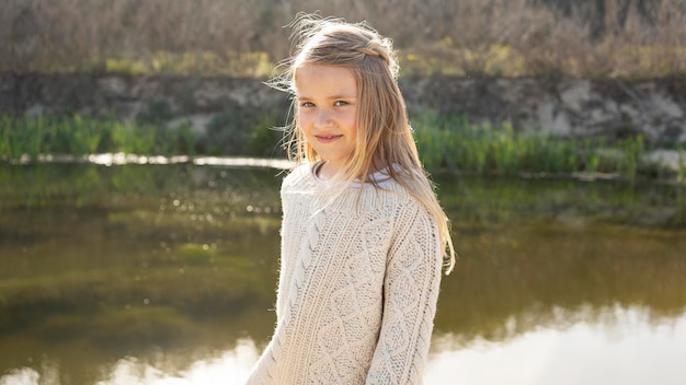 Portret małej dziewczynki na zewnątrz nad jeziorem