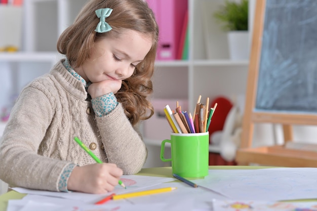 Portret małej dziewczynki rysującej w swoim pokoju