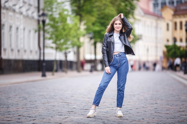 Portret małej pięknej stylowej dziewczynki w miejskiej ulicy miasta