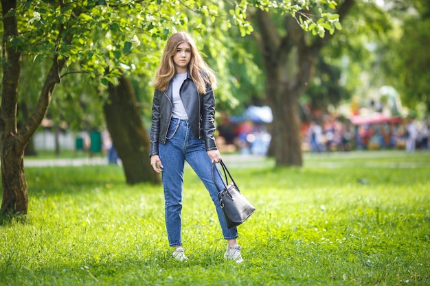 Portret Małej Pięknej Stylowej Dziewczynki W Parku Miejskim Na Tle Zielonego Lasu