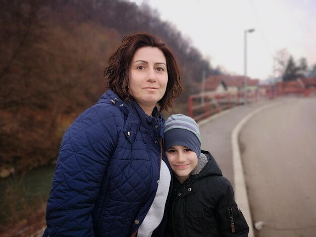 Zdjęcie portret matki i syna stojących w mieście