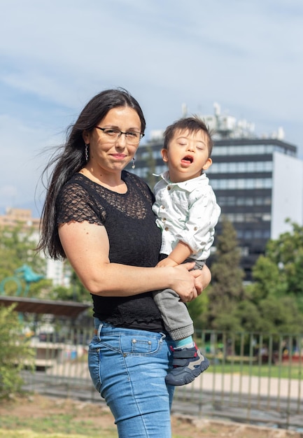 Zdjęcie portret matki trzymającej w ramionach syna z zespołem downa