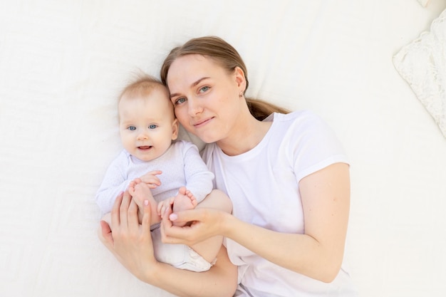 Portret Matki Z Dzieckiem W Ramionach Delikatnie Obejmująca Go Na Białym łóżku W Domu Miłość Matki