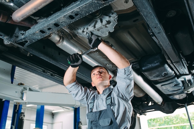 Portret Mechanika Naprawiającego Podniesiony Samochód