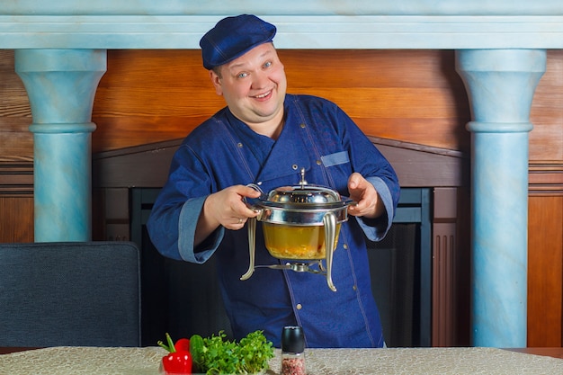 Portret męska szefa kuchni kucharza mienia niecka. Koncepcja naczynia kuchenne.