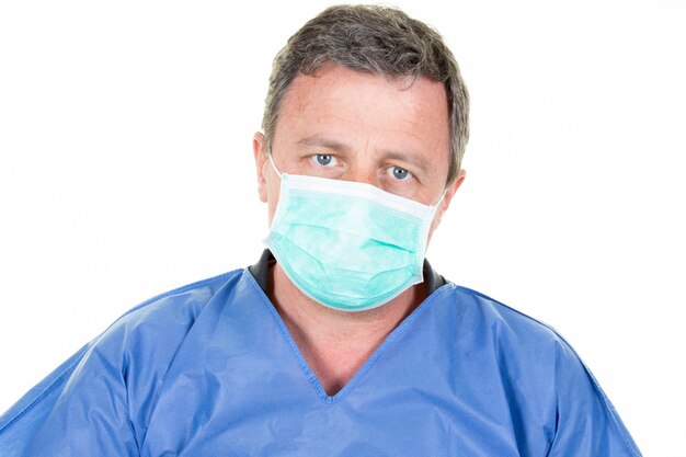 Portret męski pielęgniarka mężczyzna jest ubranym medycznego maskowego błękitnego białego tła zdrowie Coronavirus ochronnego pojęcie