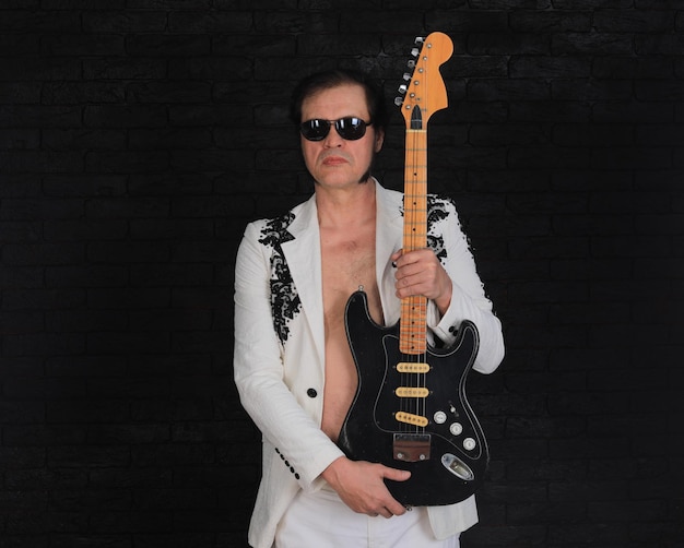 Zdjęcie portret męskiego gitarzysty rockowego na czarnym tle