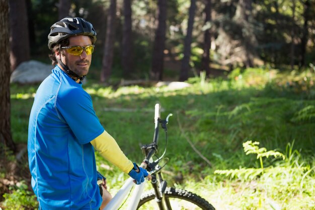 Portret męskiego mężczyzna halny rowerzysta z bicyklem w lesie