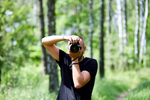 Portret męskiej fotografki zakrywającej twarz aparatem