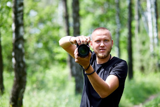 Portret męskiej fotografki zakrywającej twarz aparatem