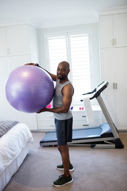 Portret mężczyzny ćwiczeń z piłką fitness w sypialni