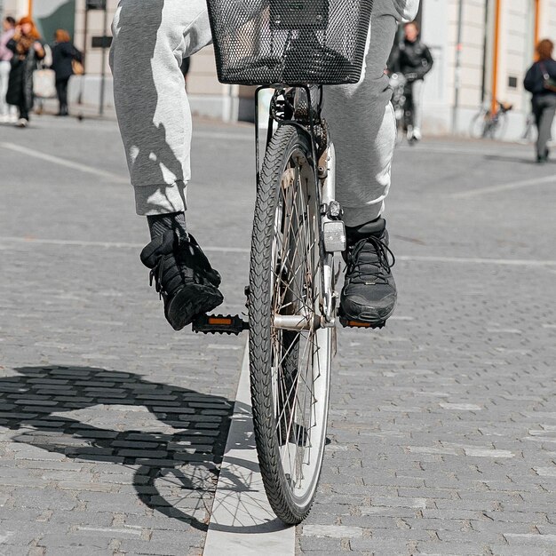 Portret mężczyzny-hipstera Mężczyzna w dużym mieście, jadąc ulicą na rowerze, koncepcja stylu życia