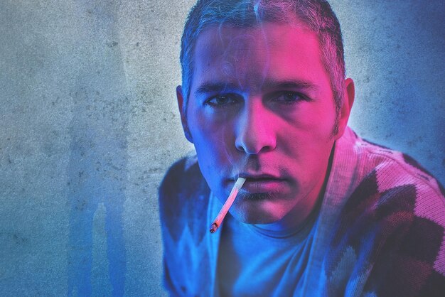 Zdjęcie portret mężczyzny palącego papierosa z wysokim kątem