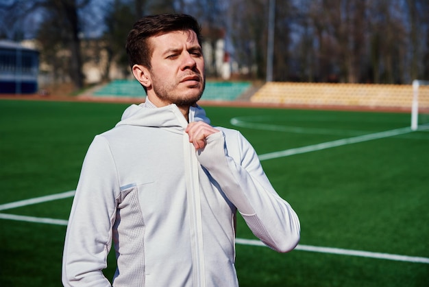 Portret mężczyzny przygotowującego się do fitnessu na torze stadionowym