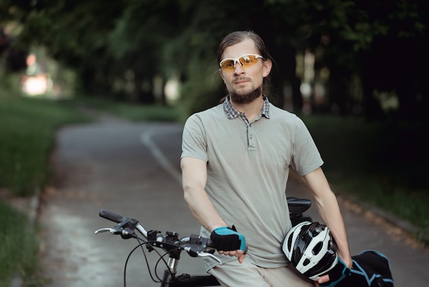 Portret Mężczyzny Rowerzysty Stojącego Na Zewnątrz W Ciepłe Lato Przeciwko Leśnej Drodze