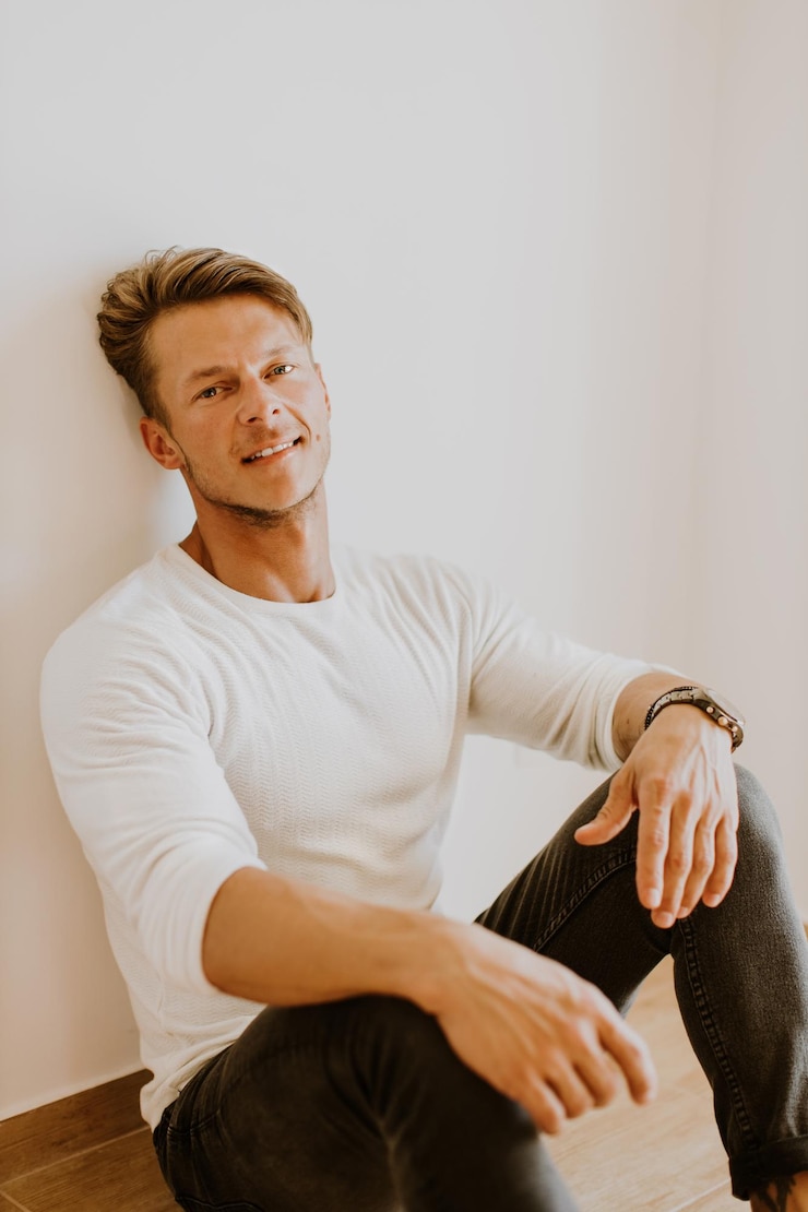 Zdjęcie portret mężczyzny siedzącego przy ścianie w domu