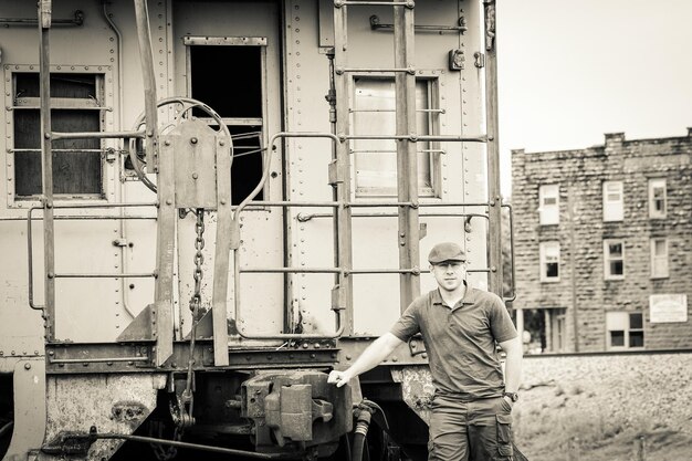 Zdjęcie portret mężczyzny stojącego przed opuszczonym pociągiem