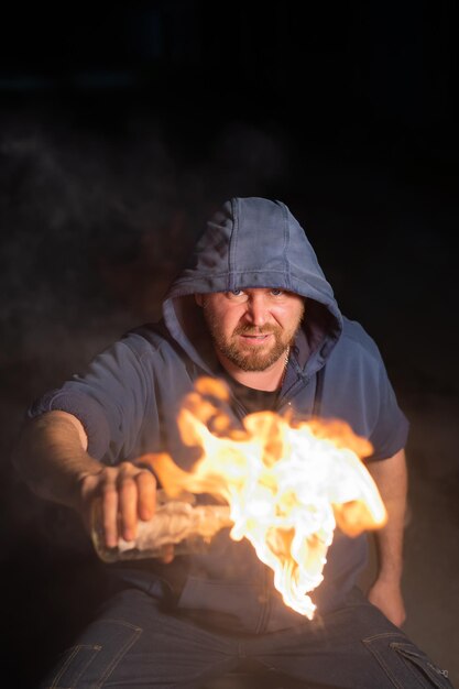 Zdjęcie portret mężczyzny stojącego przy ognisku w nocy