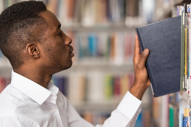 Portret mężczyzny studenta w bibliotece Płytka głębia ostrości