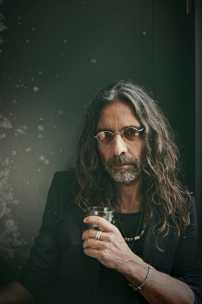 Zdjęcie portret mężczyzny trzymającego szklankę do picia w pomieszczeniu