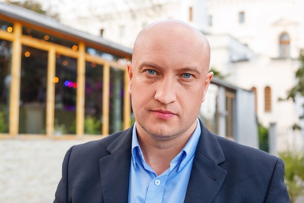 portret mężczyzny w koszuli na tle ulicy biznesmen