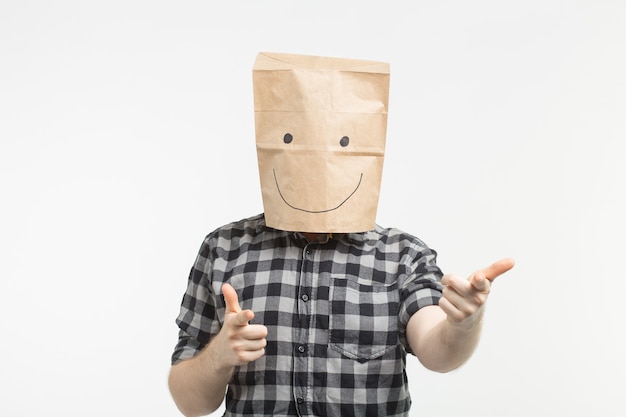 Zdjęcie portret mężczyzny w szczęśliwej masce papierowej torby na białym tle