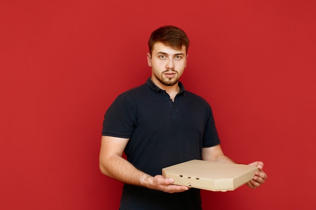 Portret mężczyzny z brodą z pudełkiem pizzy w jego rękach