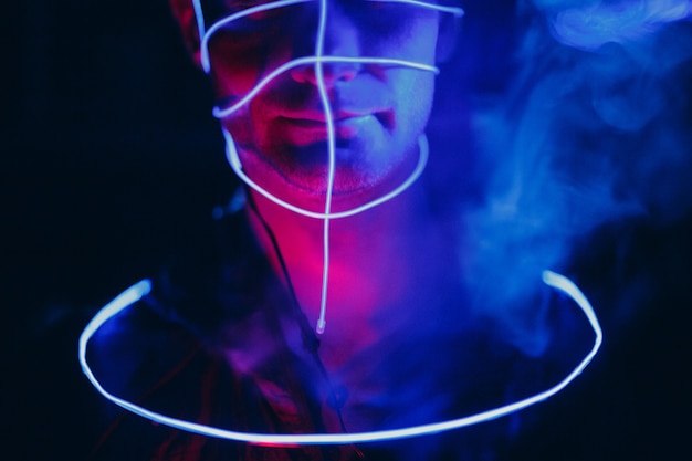Portret mężczyzny z neonowymi liniami blasku na twarzy. Pojęcie cyberpunk i wirtualnej rzeczywistości.
