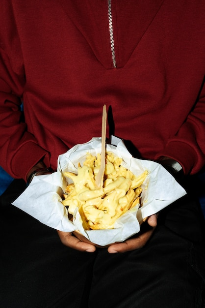 Portret mężczyzny z pysznym daniem poutine