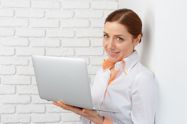 Portret młoda biznesowa kobieta używa laptop przy biurem