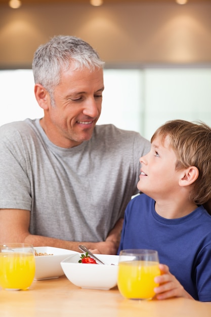 Portret młoda chłopiec i jego ojciec ma śniadanie