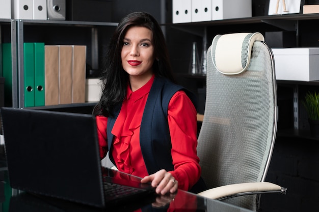 Portret młoda dziewczyna z laptopem w biurze
