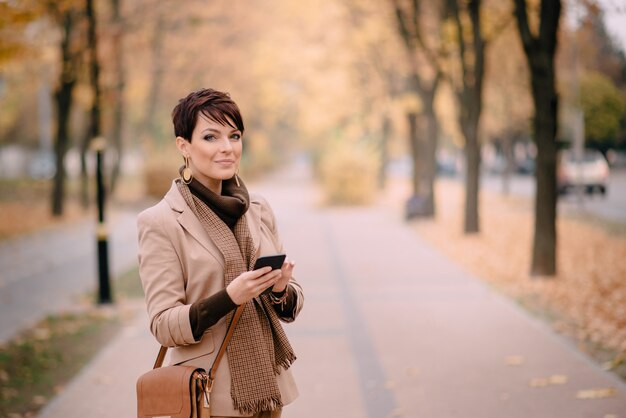 Portret młoda kobieta używa telefon na ulicie