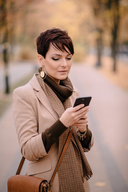 Portret Młoda Kobieta Używa Telefon Na Ulicie