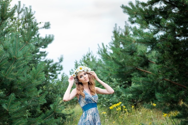 Portret młoda ładna kobieta z kółeczkiem rumianek kwitnie na głowie, outdoors, fryzura