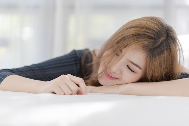 Portret młoda piękna seksowna Azjatycka kobieta relaksuje w jej sypialni. Uśmiech szczęśliwa twarz dziewczyny