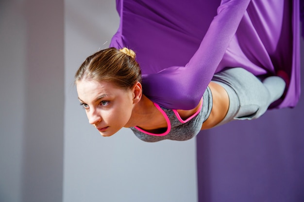 Portret młode kobiety robi antigravity joga. Trening fitness trenera lotniczej aero fly.