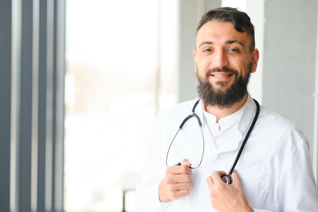 Portret młodego arabskiego lekarza stojącego w klinice