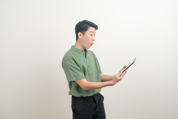 portret młodego azjatyckiego mężczyzny używającego tabletu na białym tle