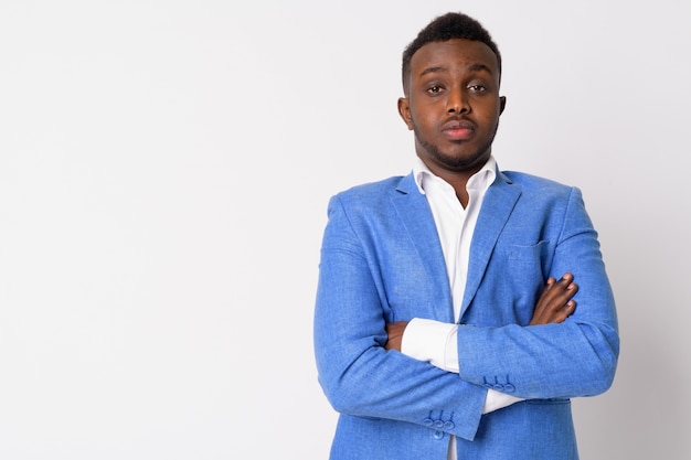 Portret młodego biznesmena afrykańskiego na sobie niebieski garnitur przed białą ścianą
