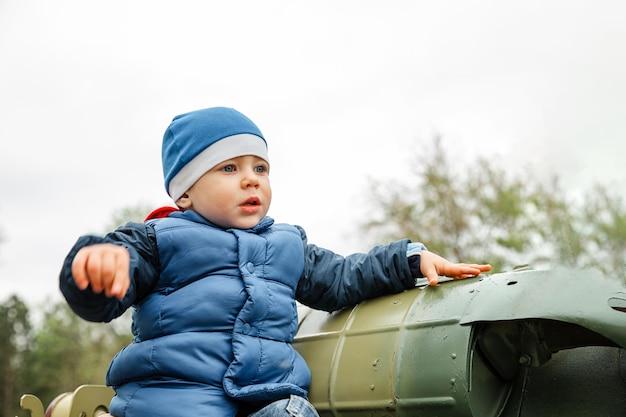 Portret młodego chłopca Chłopiec bawi się czołgiem wojskowym