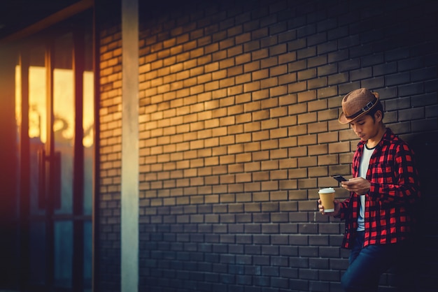 Portret młodego człowieka mienia telefon komórkowy i filiżanka kawa