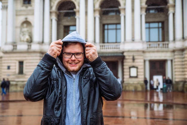 Portret młodego dorosłego człowieka z okularami w kroplach i przykryć kapturem. mężczyzna z mokrymi włosami