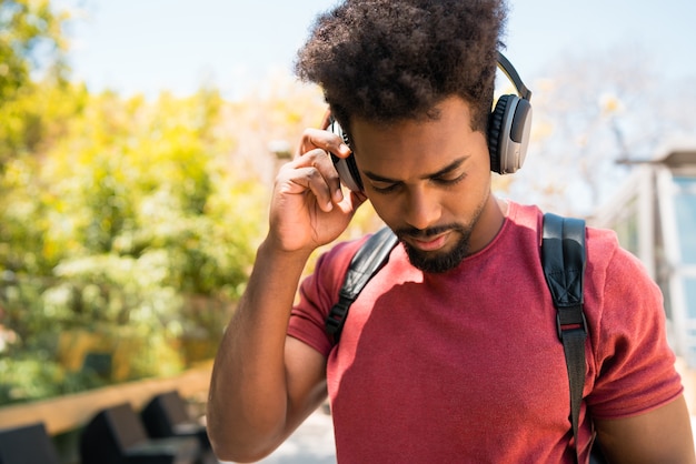 Portret młodego mężczyzny afro, ciesząc się i słuchając muzyki w słuchawkach
