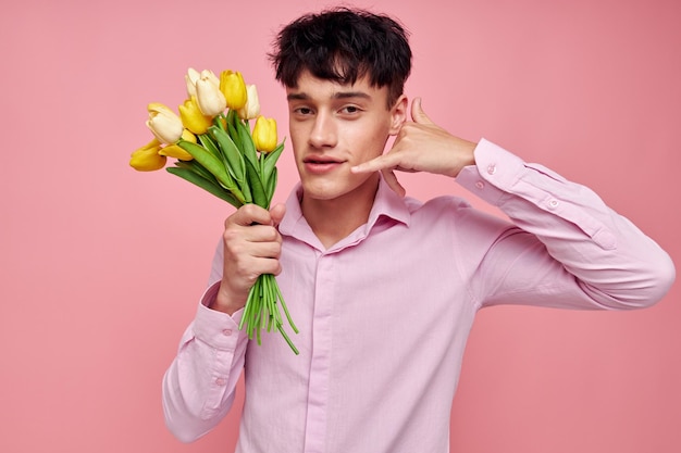 Portret młodego mężczyzny bukiet kwiatów data romans pozowanie różowe tło niezmienione