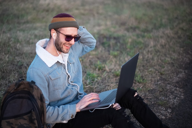 Portret Młodego Mężczyzny Hipster Za Pomocą Laptopa Na Zewnątrz