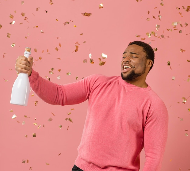 Zdjęcie portret młodego mężczyzny na imprezie z butelką szampana