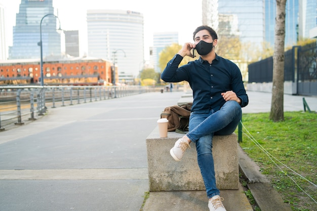 Portret Młodego Mężczyzny Rozmawia Przez Telefon Siedząc Na ławce Na świeżym Powietrzu. Nowa Koncepcja Normalnego Stylu życia.